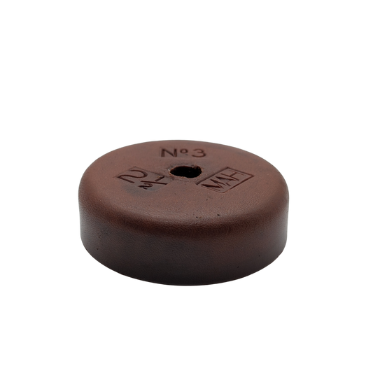 Brown round object with measurements on a white background